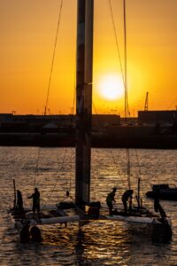 Membrii echipei Switzerland SailGP finalizează ultimele pregătiri pentru catamaranul lor F50 la răsăritul soarelui, înainte de a lua parte la o sesiune de antrenament înainte de Marele Premiu al Spaniei la Cadiz, Spania. Foto: Felix Diemer pentru SailGP.