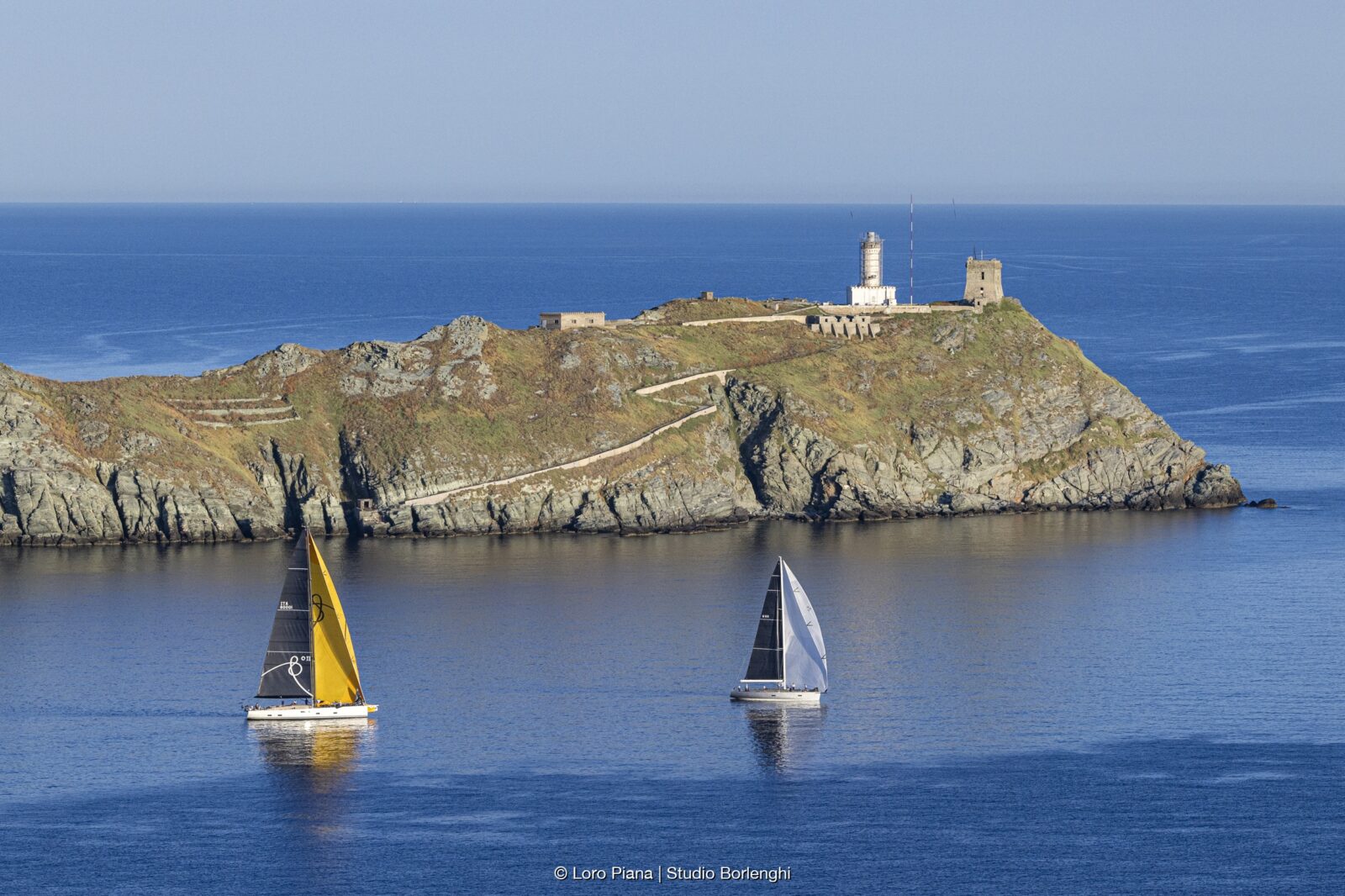 Grand Soleil 80 LC Bianca II îl urmează pe Wally 60 Wallyño al lui Benoît de Froidmont pe lângă stânca Giraglia. Foto: Loro Piana/Studio Borlenghi